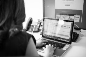 Woman using laptop with audio recording displayed on screen