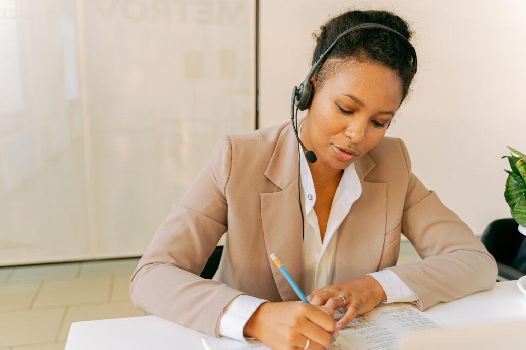 Woman on call while taking notes using a wireless VoIP headset